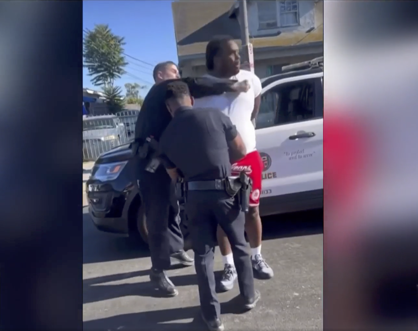 Screenshot of an unidentified LAPD officer punching a man in the face with their right fist.